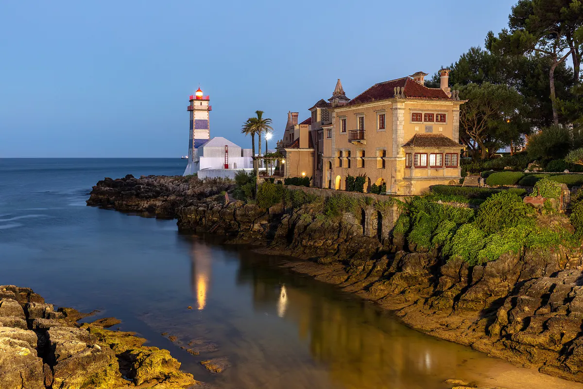 Santa Marta lighthouse in Cascais at blue hour, reflected in the still water