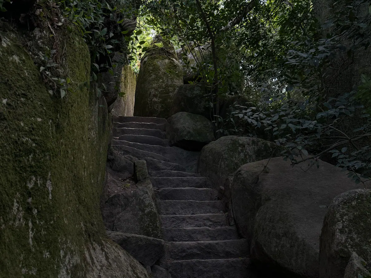 Mossy stone steps between granite boulders in the Sintra forest
